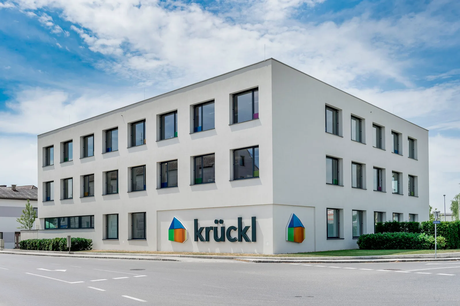 Firmenzentrale von Krückl Bau in Perg, dreigeschoßiger weißer Bau mit dem Schriftzug krückl