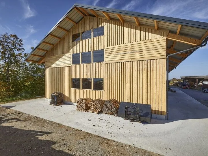 Landwirtschaftliches Gebäude mit senkrechter Holzschalung und weitem Dachvorsprung